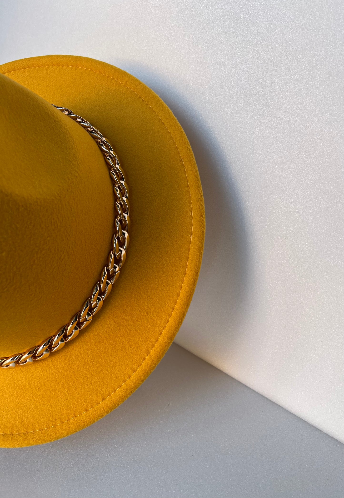 Cappello giallo ocra con catena dorata